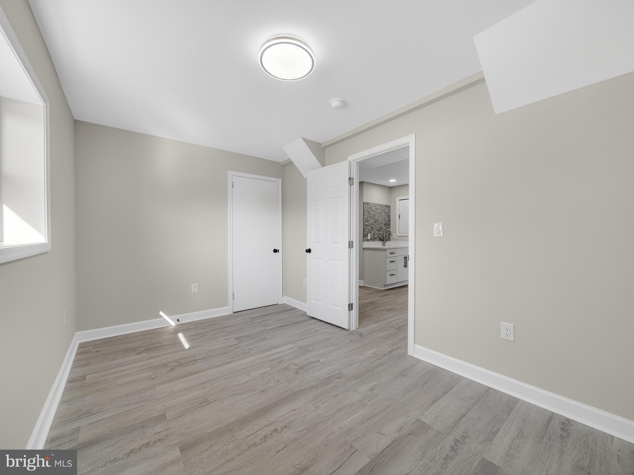 24676 Old 3 Notch Road Hollywood, MD 20636 - Photo 39 of 45 an empty room with wooden floor and windows