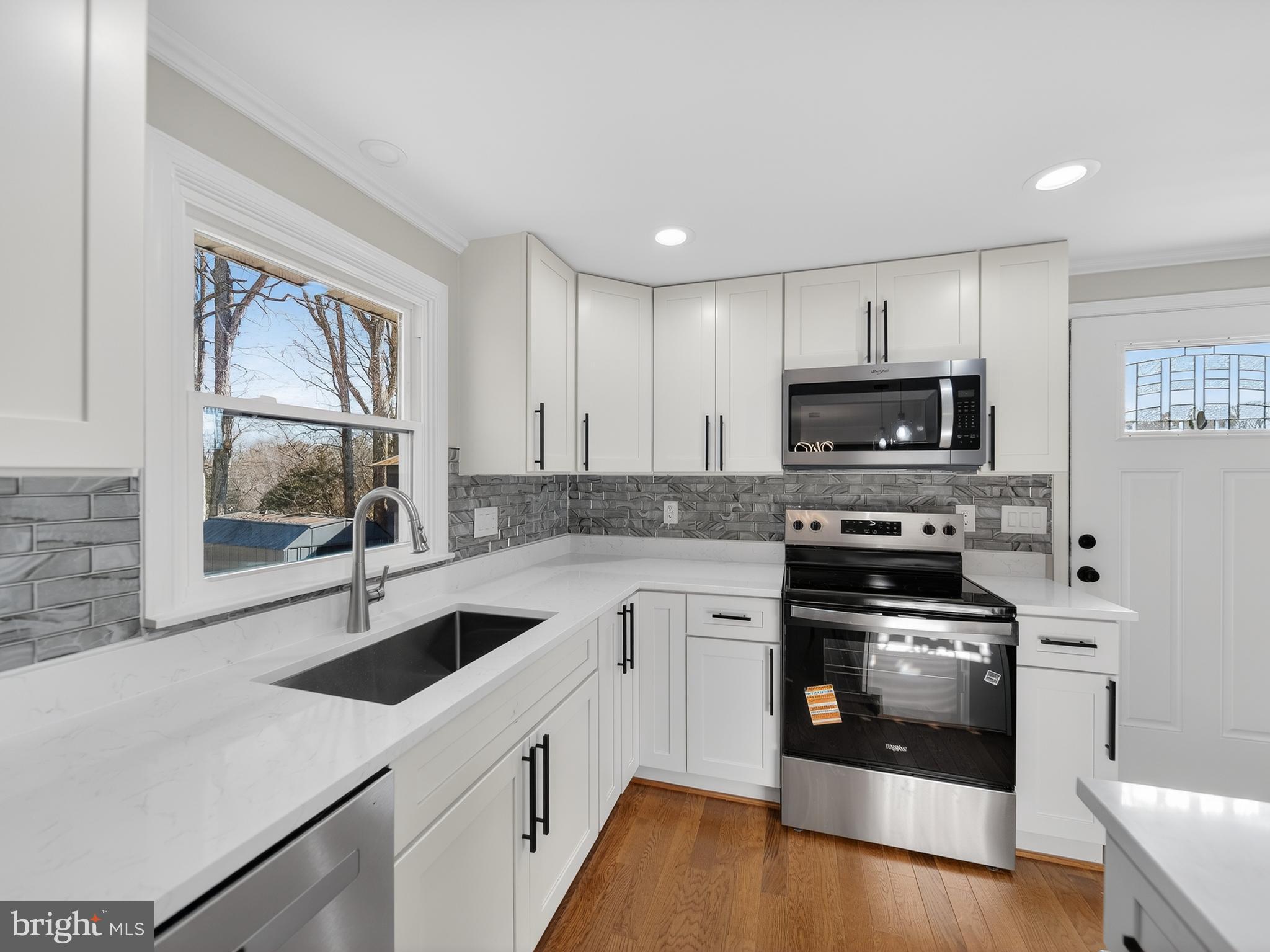 24676 Old 3 Notch Road Hollywood, MD 20636 - Photo 9 of 45 a kitchen with a sink a stove and wooden floor