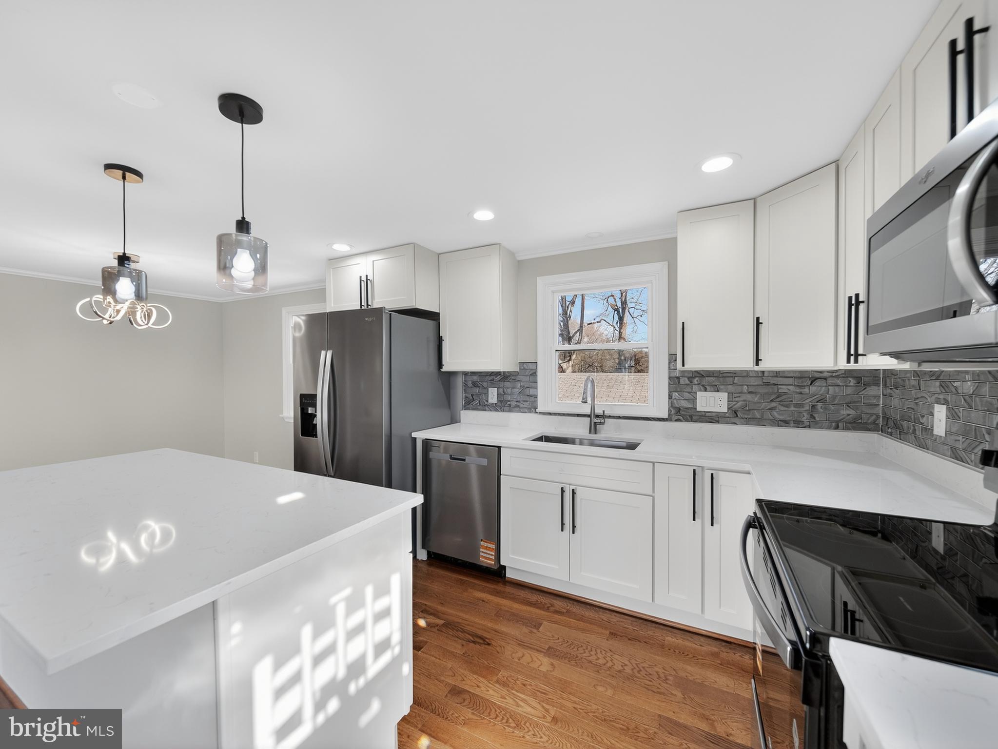 24676 Old 3 Notch Road Hollywood, MD 20636 - Photo 10 of 45 a kitchen with stainless steel appliances granite countertop a refrigerator a sink dishwasher a stove and a dining table with wooden floor