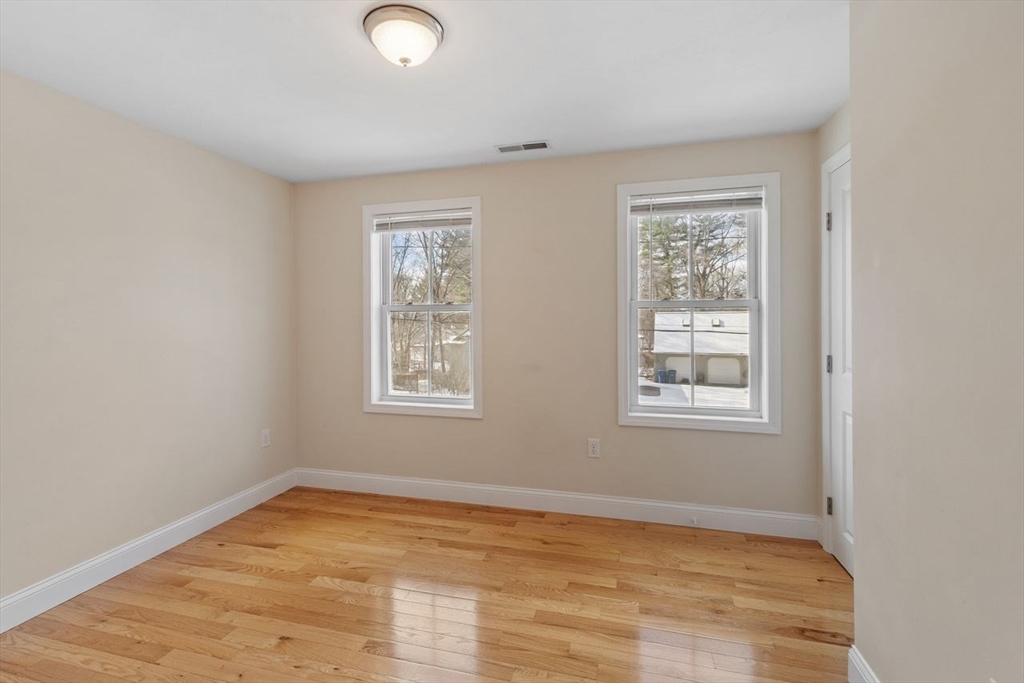 51 Valley Road Tewksbury, MA 01876 - Photo 11 of 17 a view of an empty room with wooden floor and a window