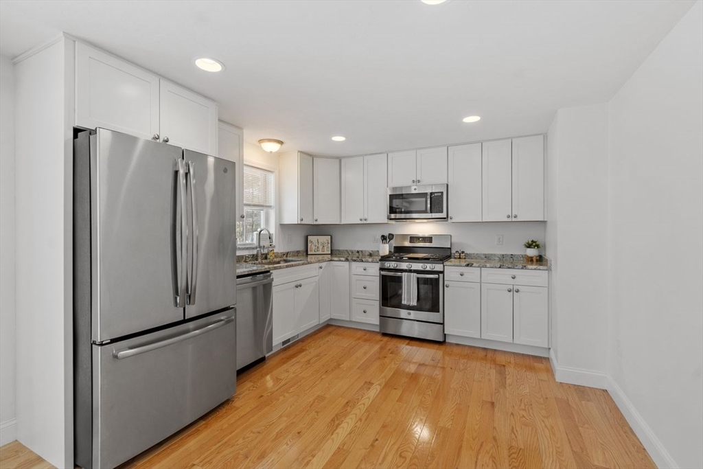 51 Valley Road Tewksbury, MA 01876 - Photo 7 of 17 a kitchen with a refrigerator a stove top oven a sink and cabinets