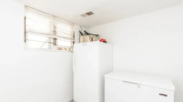 a utility room with fridge dryer and washer