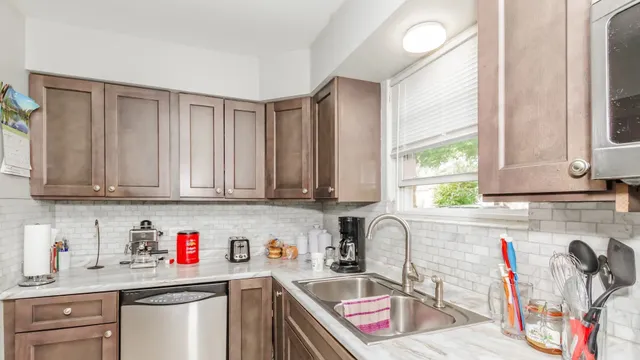 a kitchen with stainless steel appliances granite countertop a sink dishwasher and cabinets with wooden floor