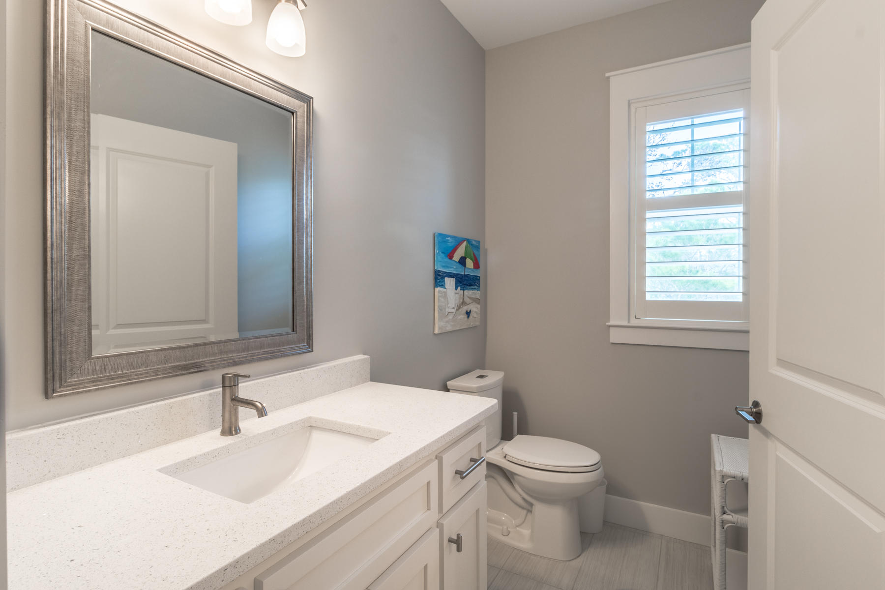 119 Michaela Lane Santa Rosa Beach, FL 32459 - Photo 19 of 28 a bathroom with a toilet a sink a mirror and a window