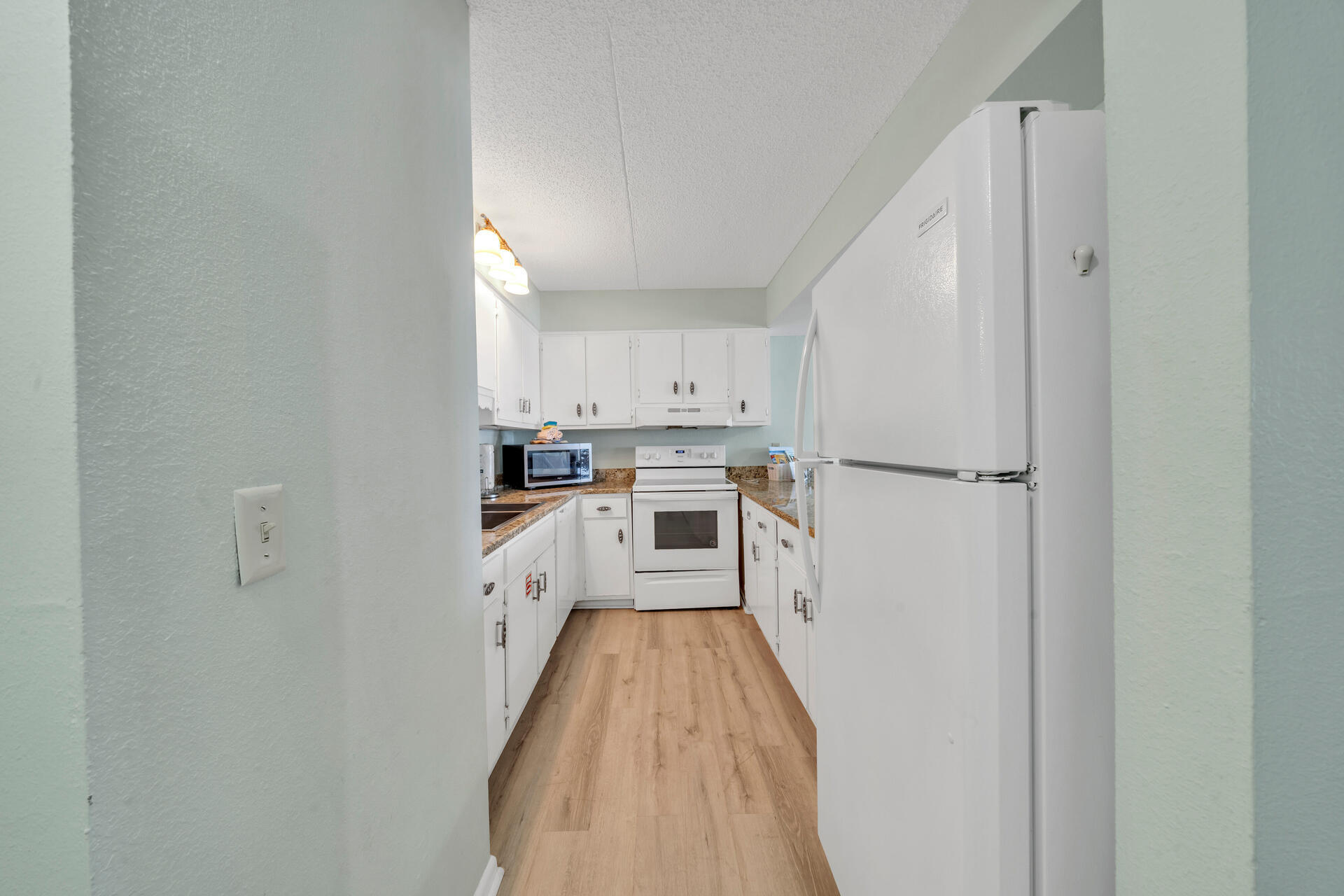 676 Santa Rosa Boulevard, Unit 4D Fort Walton Beach, FL 32548 - Photo 12 of 30 a kitchen with white cabinets and white appliances