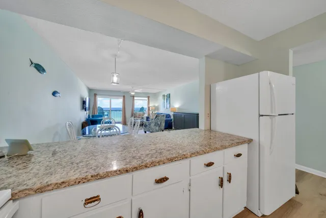 a kitchen with granite countertop white cabinets and white appliances