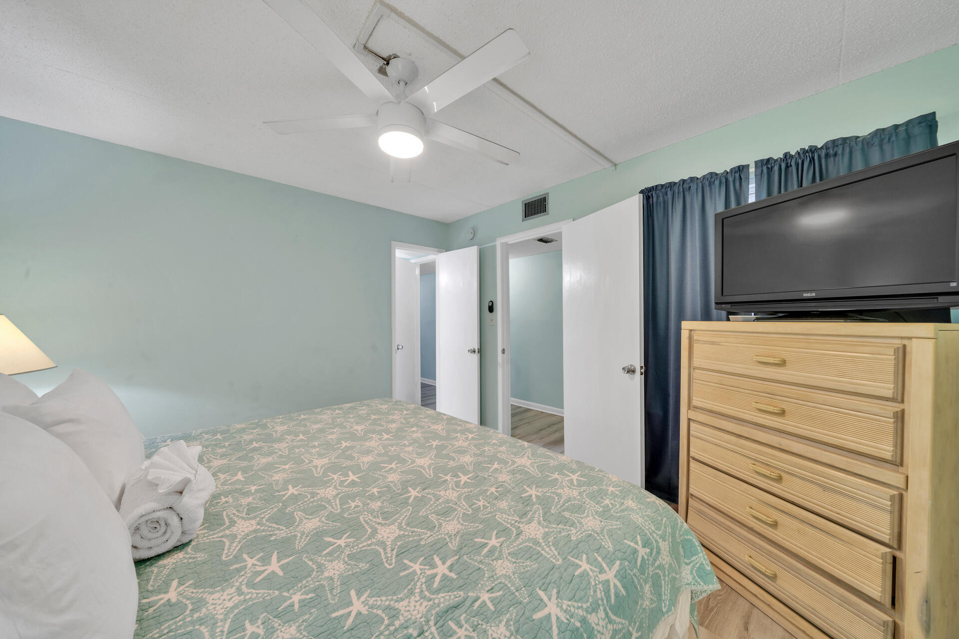 676 Santa Rosa Boulevard, Unit 4D Fort Walton Beach, FL 32548 - Photo 10 of 30 a bedroom with a large bed and a flat screen tv