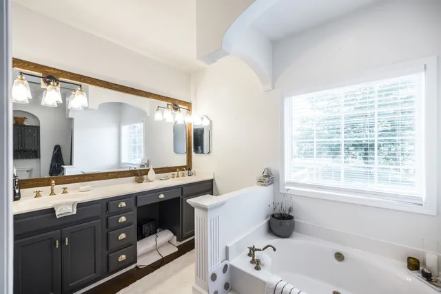 a bathroom with a sink a toilet a mirror and shower