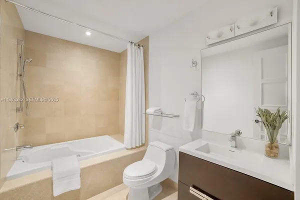 a bathroom with a sink a toilet a tub and shower