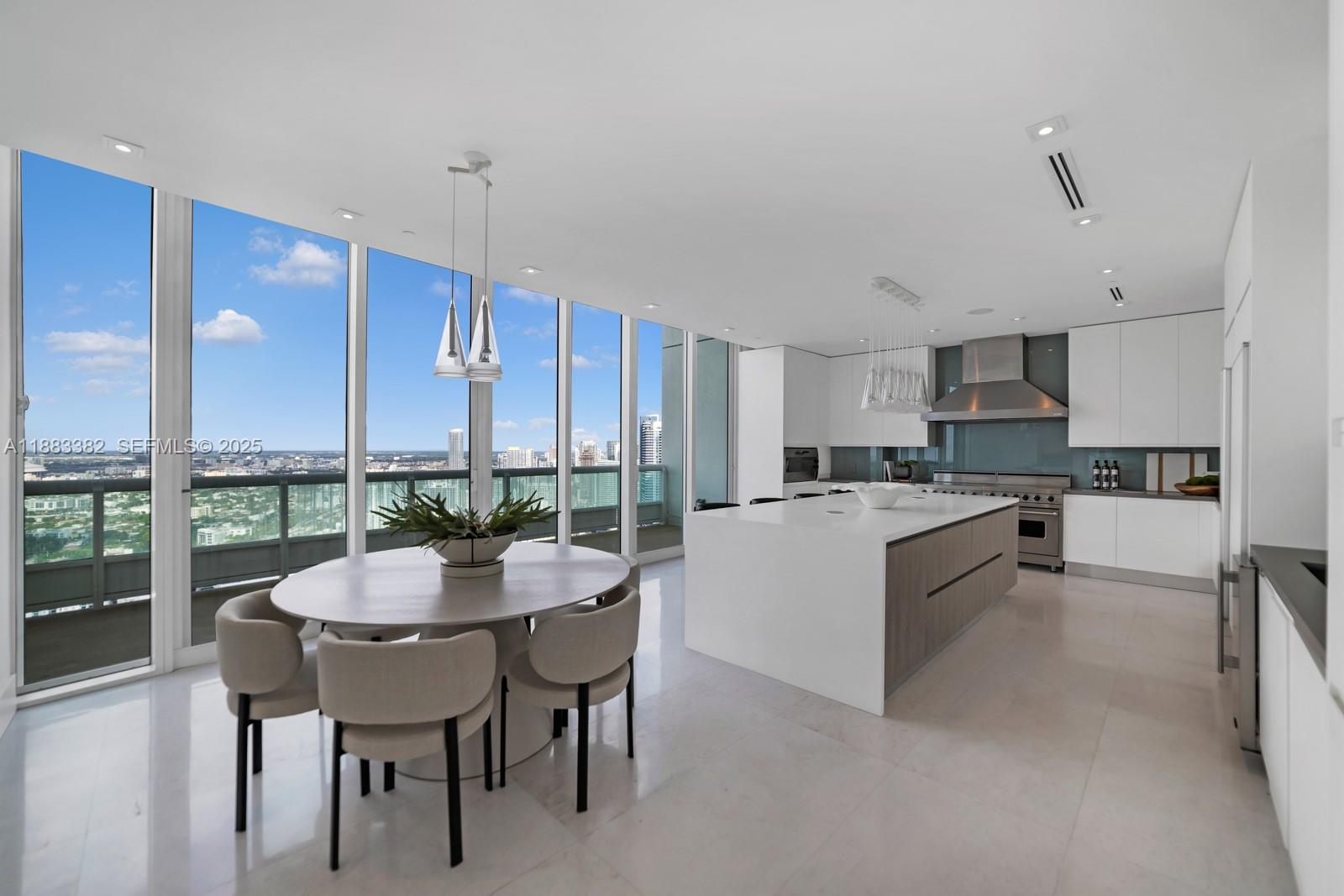 1643 Brickell Avenue, Unit PH4902 Miami, FL 33129 - Photo 7 of 38 a kitchen with a dining table chairs and white cabinets