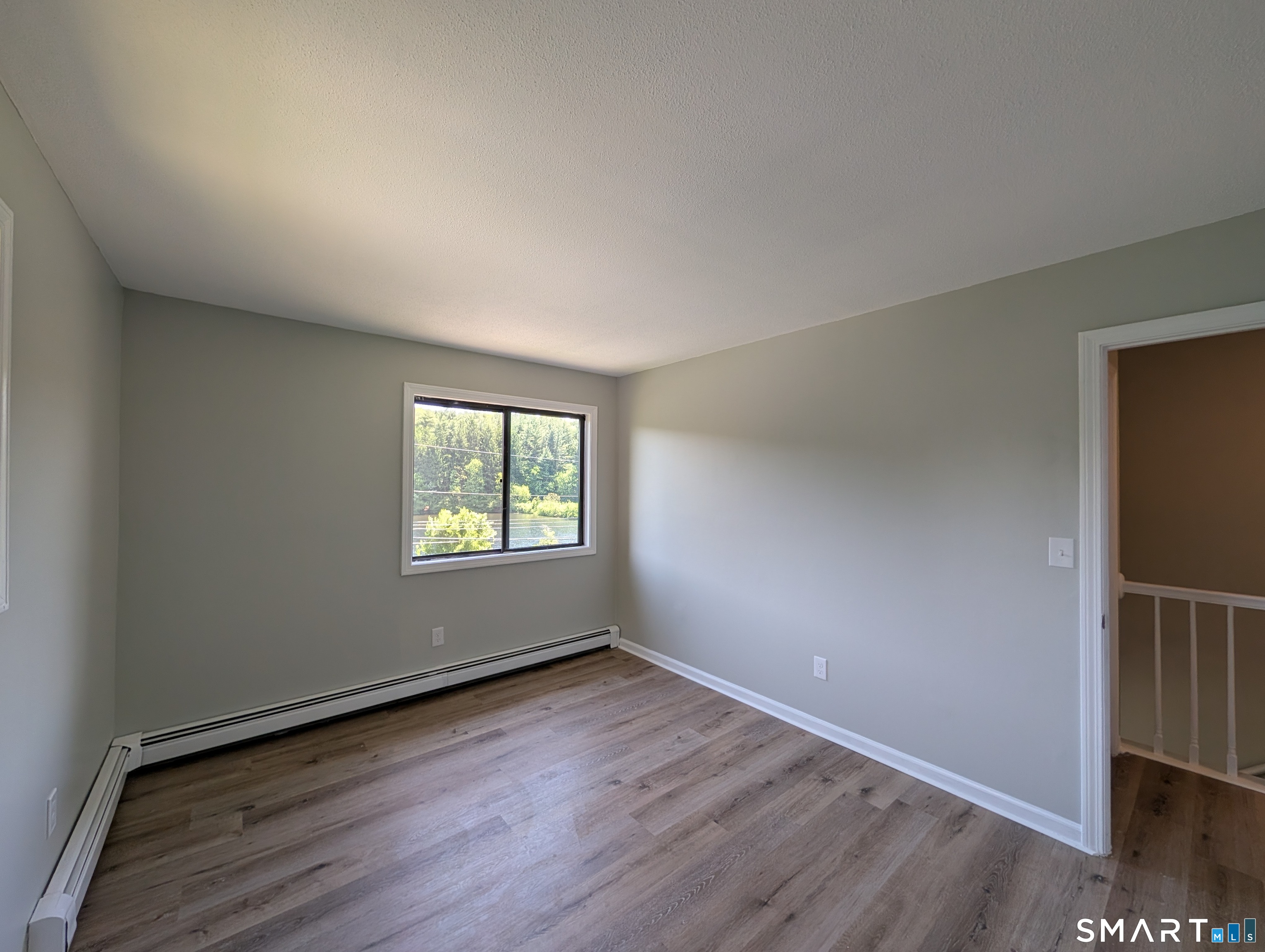 267 Beaver Street Ansonia, CT 06401 - Photo 8 of 12 an empty room with wooden floor and windows