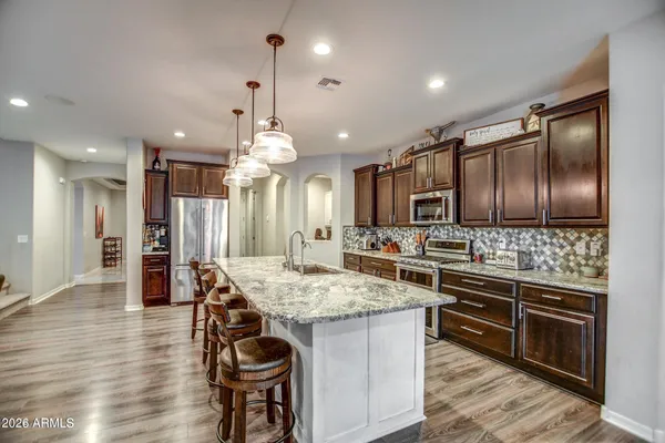 a kitchen with granite countertop a stove oven and refrigerator