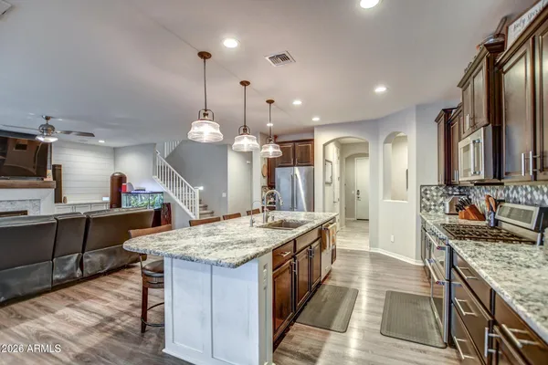 a large kitchen with kitchen island a sink stove and wooden floor