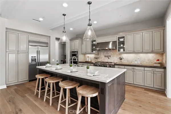 a kitchen with kitchen island granite countertop a sink a center island and stainless steel appliances