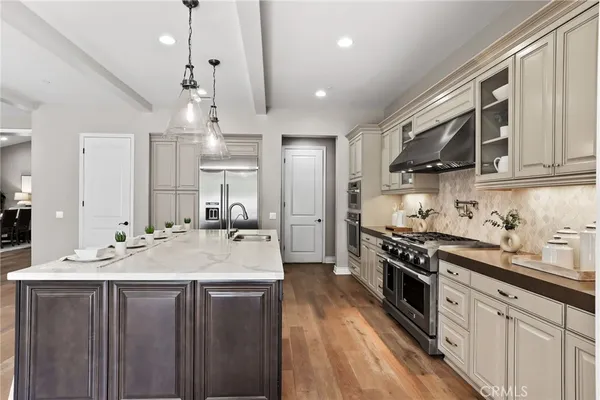 a kitchen with kitchen island granite countertop a sink appliances cabinets and a counter top space