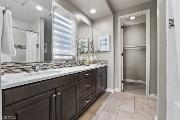 a spacious bathroom with a double vanity sink mirror and bathtub