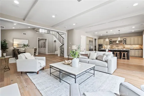 a living room with furniture kitchen view and a large window