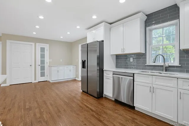 a kitchen with a refrigerator sink and cabinets