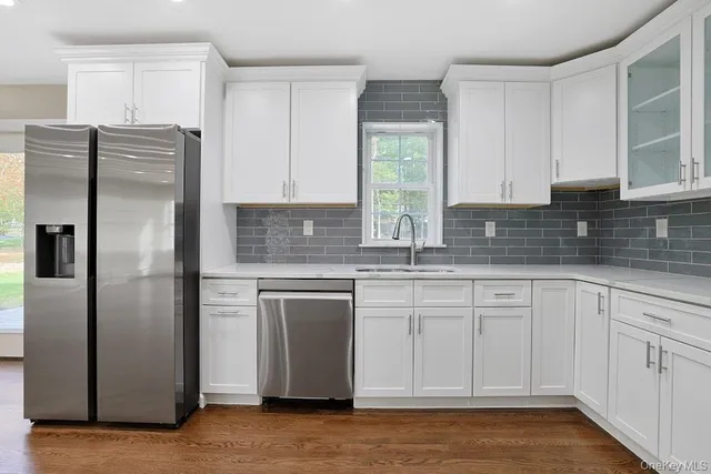 a kitchen with stainless steel appliances granite countertop a refrigerator and a sink