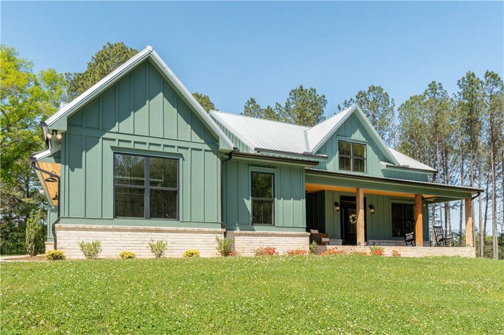 526 Brice Station Road Silver Creek, GA 30173 - Photo 2 of 32 a view of a white house with a large windows and a yard with plants and large trees