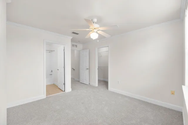 an empty room with closet and a ceiling fan