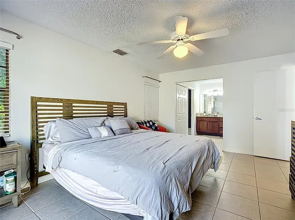 a bedroom with a large bed and a chandelier