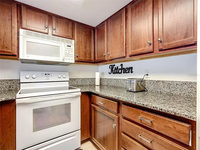 a kitchen with granite countertop cabinets stainless steel appliances and a sink