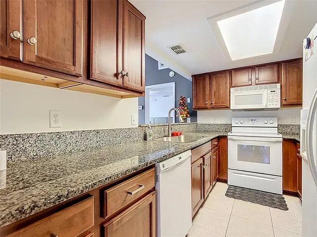 a kitchen with stainless steel appliances granite countertop a sink stove and cabinets