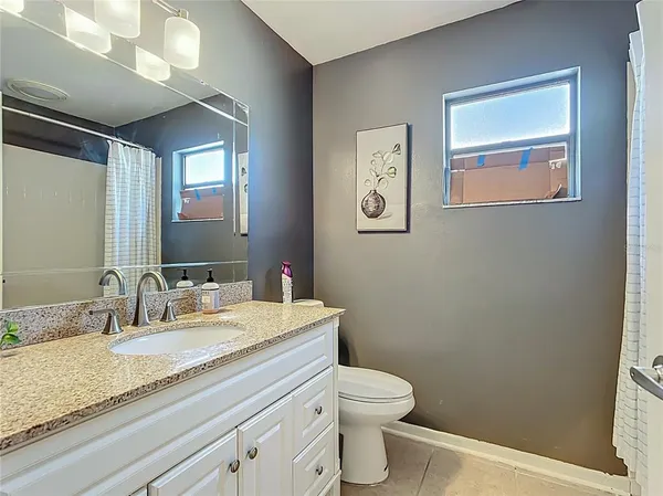 a bathroom with a granite countertop sink mirror vanity and toilet