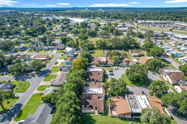 an aerial view of a house with garden space and a building