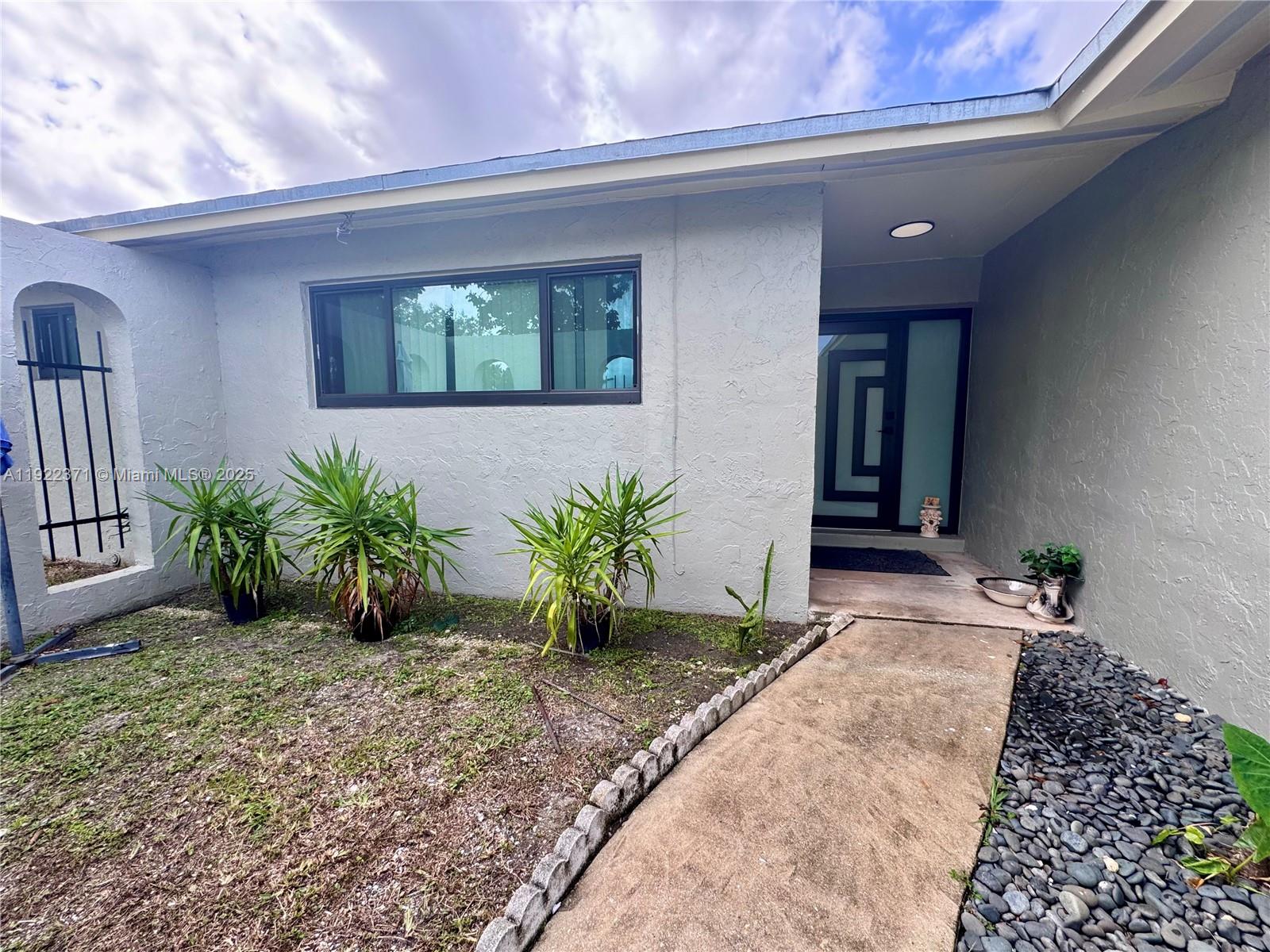 19720 Southwest 118th Place Miami, FL 33177 - Photo 14 of 21 a view of entryway with a flower garden
