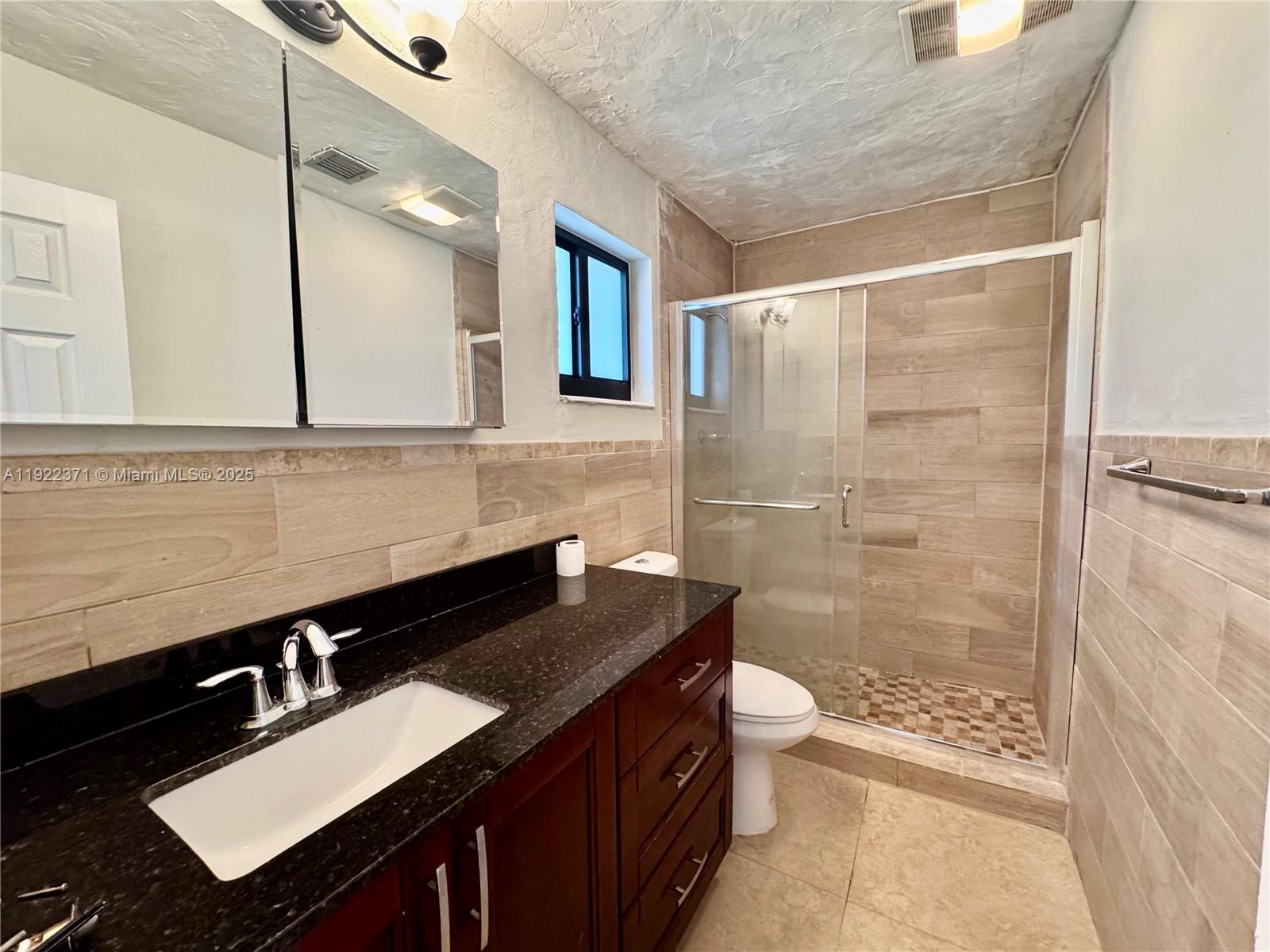 19720 Southwest 118th Place Miami, FL 33177 - Photo 19 of 21 a bathroom with a sink a toilet a mirror and shower