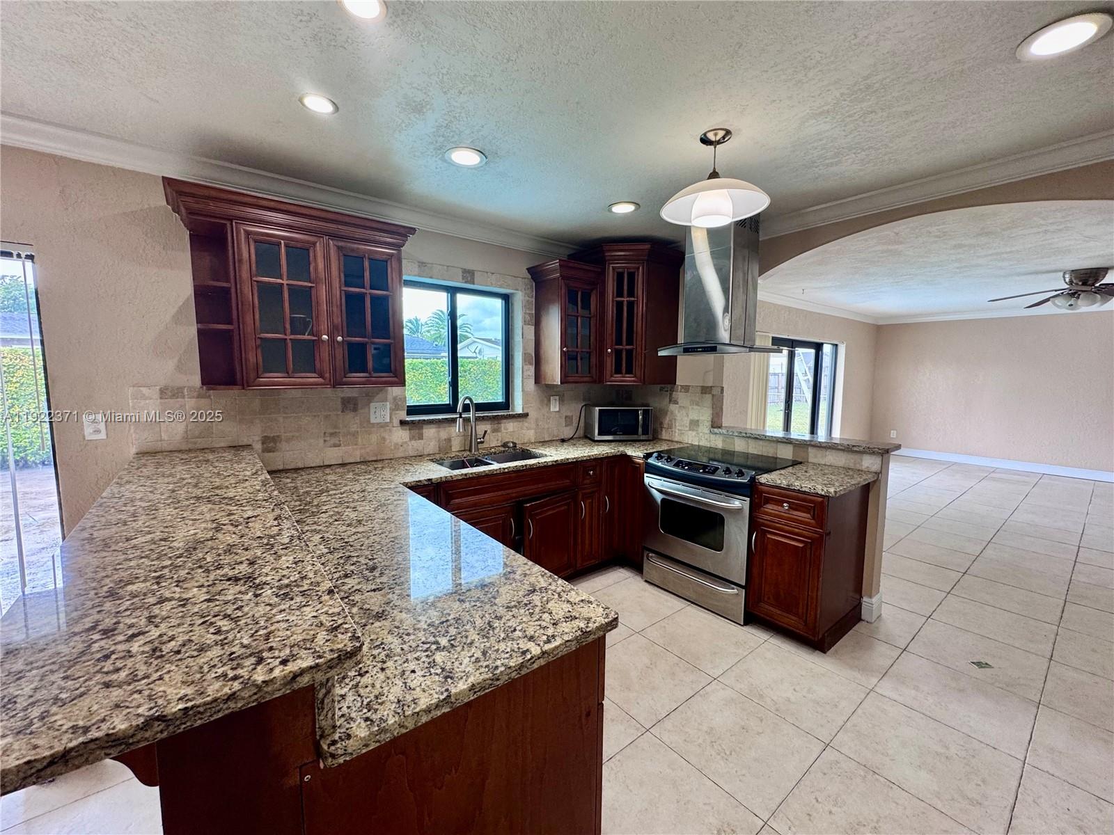 19720 Southwest 118th Place Miami, FL 33177 - Photo 2 of 21 a kitchen with granite countertop a sink and a stove