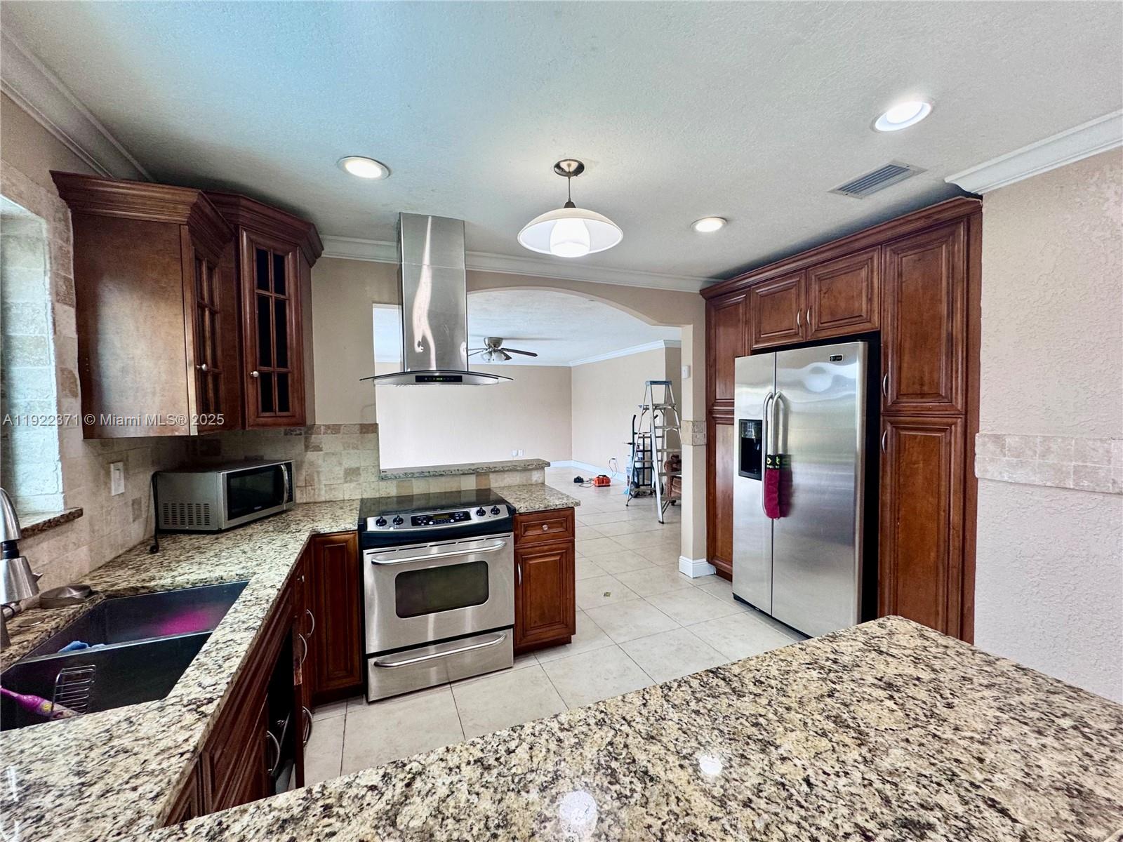 19720 Southwest 118th Place Miami, FL 33177 - Photo 3 of 21 a kitchen with stainless steel appliances granite countertop a sink stove and refrigerator