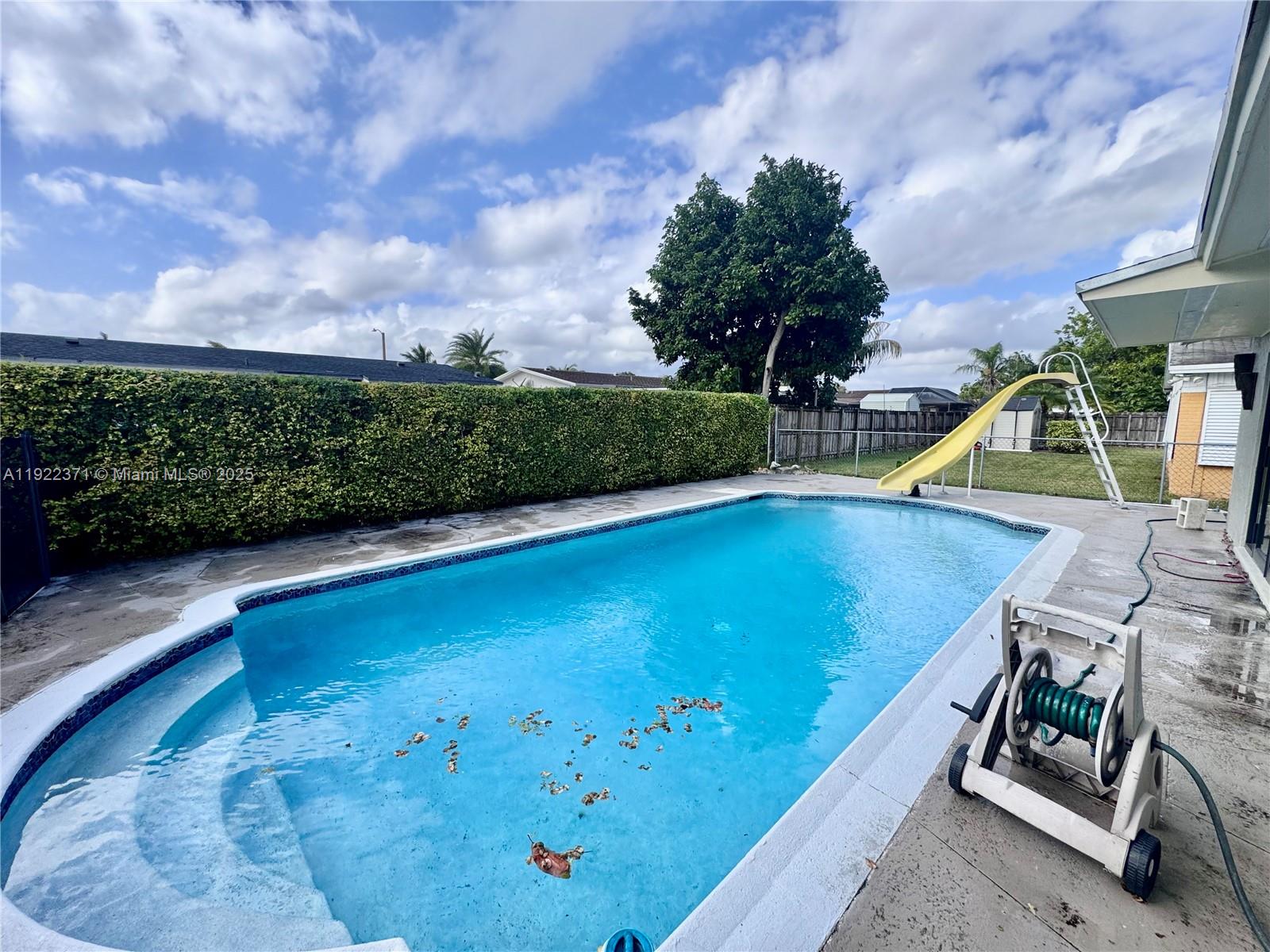 19720 Southwest 118th Place Miami, FL 33177 - Photo 5 of 21 a view of a swimming pool with an outdoor seating and a garden