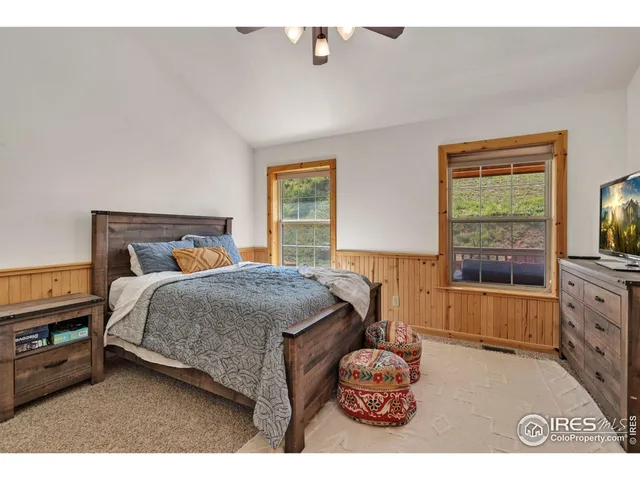 a bedroom with a bed a dresser next to a window