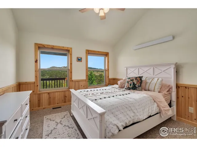 a bedroom with a bed a dresser next to a window