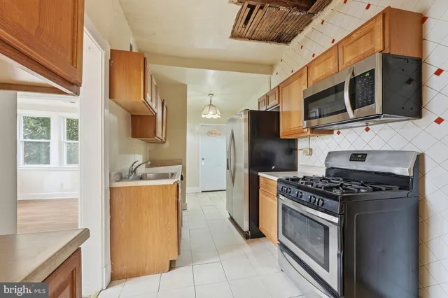 a kitchen with stainless steel appliances granite countertop a stove microwave and refrigerator