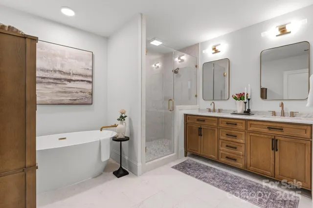 a spacious bathroom with a double vanity sink a mirror and a bathtub