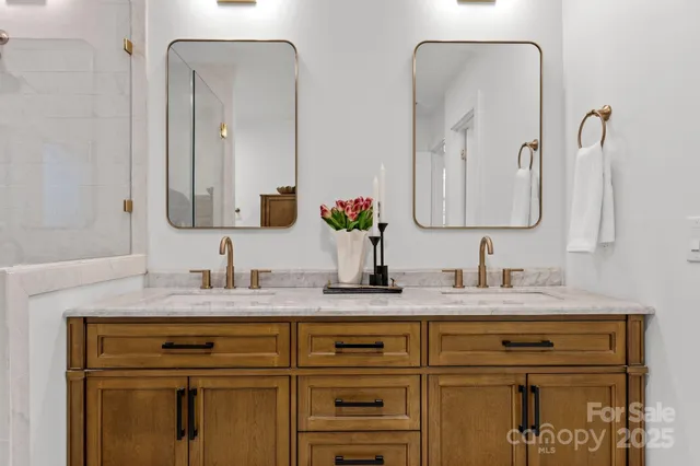a bathroom with double vanity sinks and a mirror