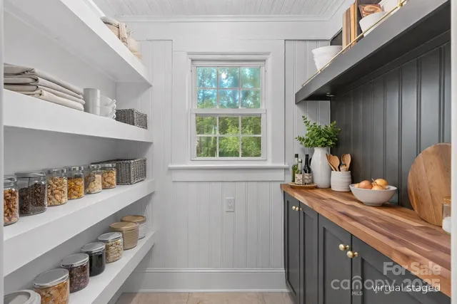 a kitchen with stainless steel appliances a sink a window and potted plants