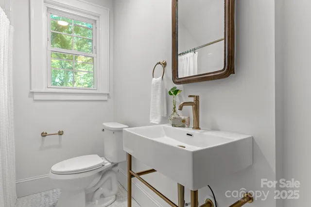 a bathroom with a toilet sink and mirror