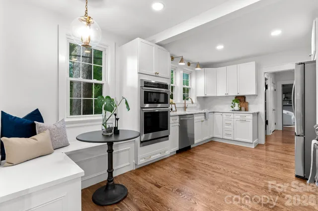 a kitchen with white cabinets and sink