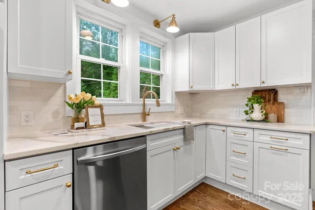 a kitchen with white cabinets and sink