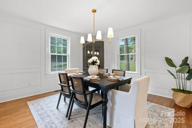 a dining room with furniture window and wooden floor