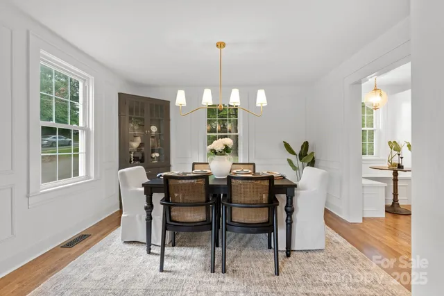 a dining room with furniture window and wooden floor