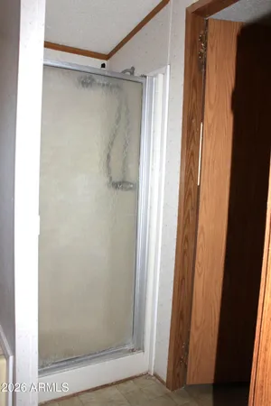 a bathroom with a glass door shower and a window