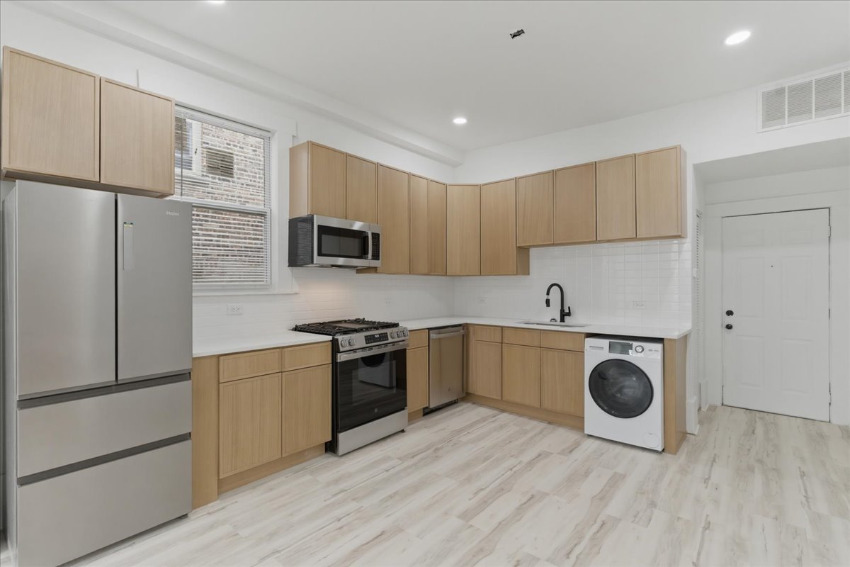 2607 West Haddon Avenue, Unit 2F Chicago, IL 60622 - Photo 3 of 12 a kitchen with a refrigerator a stove top oven and wooden floor