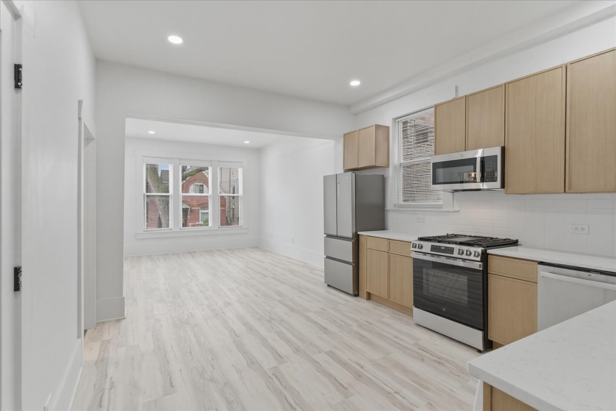 2607 West Haddon Avenue, Unit 2F Chicago, IL 60622 - Photo 5 of 12 a kitchen with stainless steel appliances granite countertop a stove a sink and a refrigerator