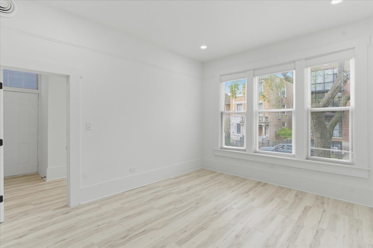 2607 West Haddon Avenue, Unit 2F Chicago, IL 60622 - Photo 6 of 12 an empty room with wooden floor and windows